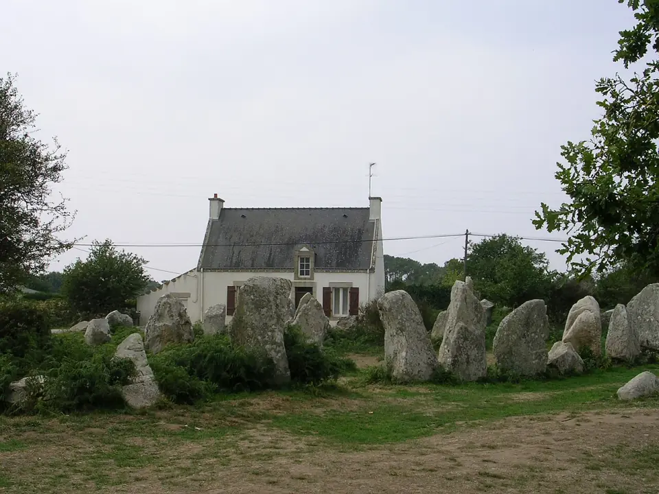 Menhirs de Kerzérho devant une maison de pierre, à Erdeven