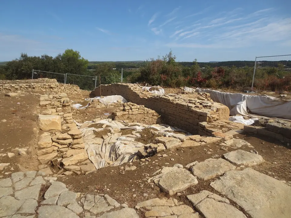 Vestiges de murs et dallages d'un quartier gallo-romain d'Ambrussum sous un ciel bleu
