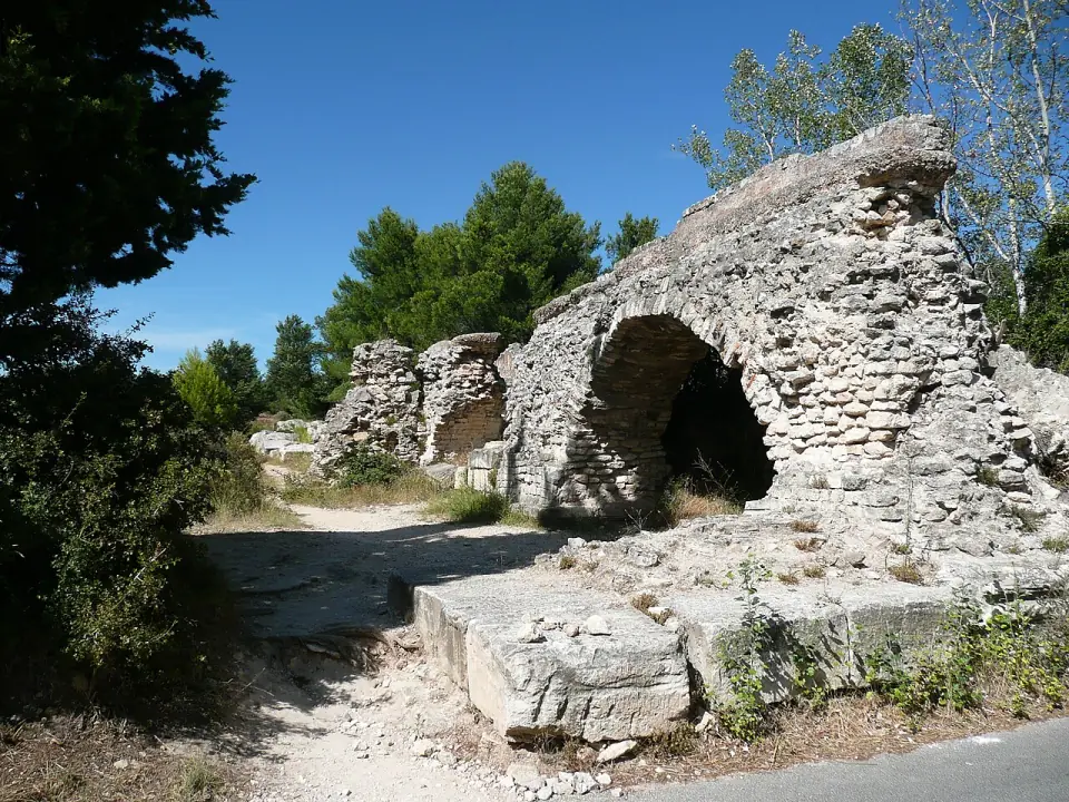 Arches ruinées en petit appareil de pierre à Barbegal, sous les pins et un ciel bleu