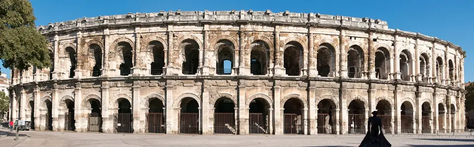 Façade des arènes de Nîmes, avec ses deux niveaux d'arcades en pierre claire et son attique