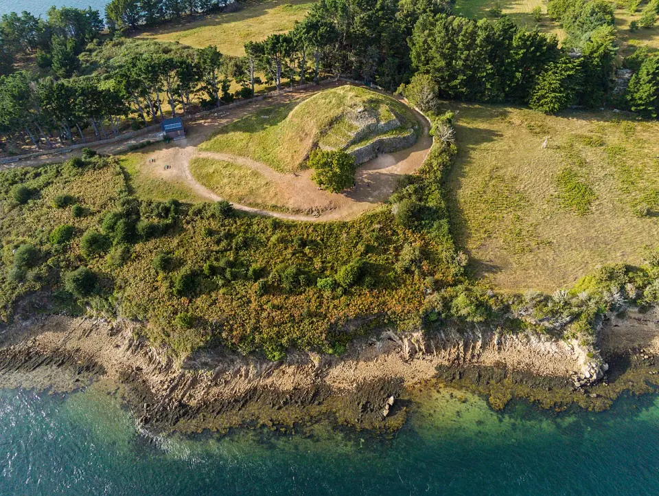 Vue plongeante sur le cairn de Gavrinis et la côte du golfe du Morbihan, en soirée