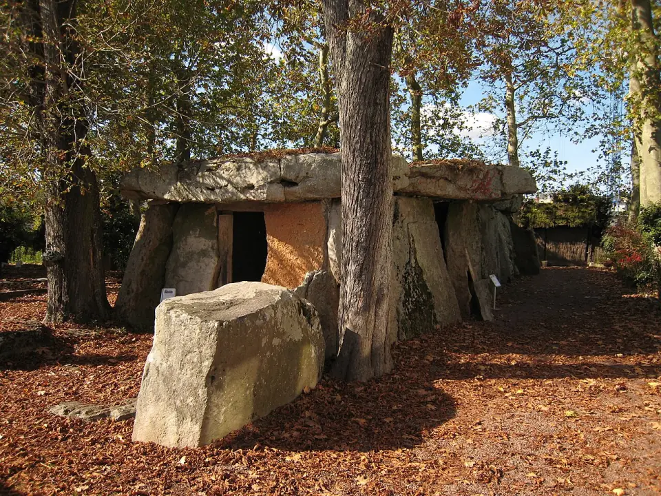 Le dolmen de Bagneux parmi les arbres, avec ses grandes dalles de grès et son entrée sur le côté
