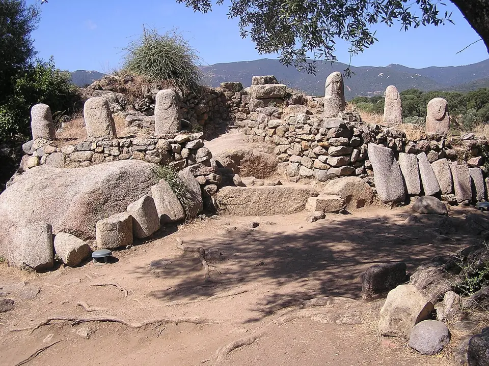 Statues-menhirs dressées au-dessus d'un mur de pierres sèches à Filitosa, avec des montagnes au loin