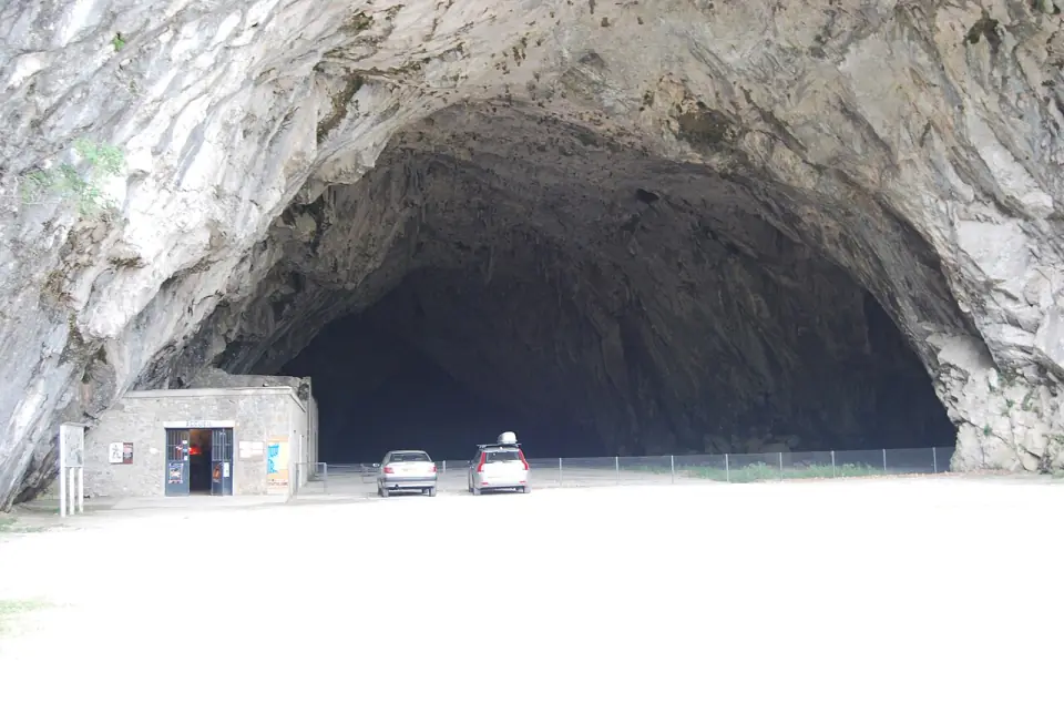 L'immense porche de la grotte de Bédeilhac, avec le bâtiment d'accueil au pied de la falaise