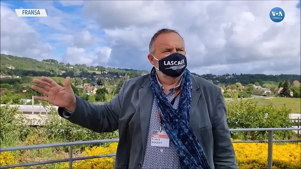 Un guide de Lascaux sur une terrasse, devant les collines boisées autour de Montignac