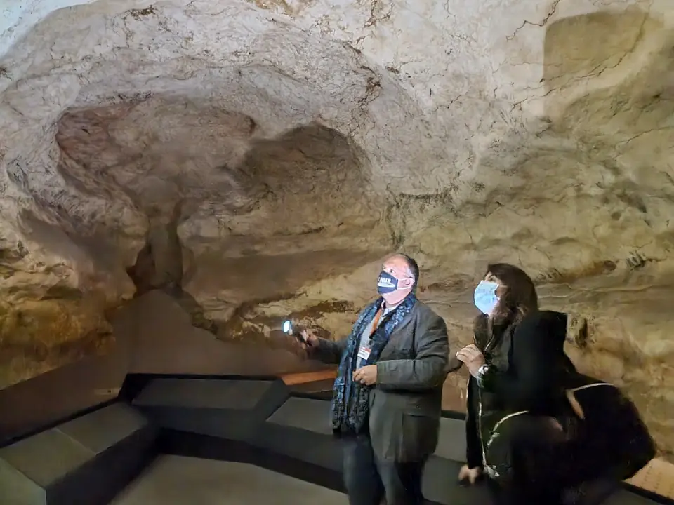 Un guide éclaire la voûte d'une salle reconstituée du fac-similé de Lascaux, près d'une visiteuse