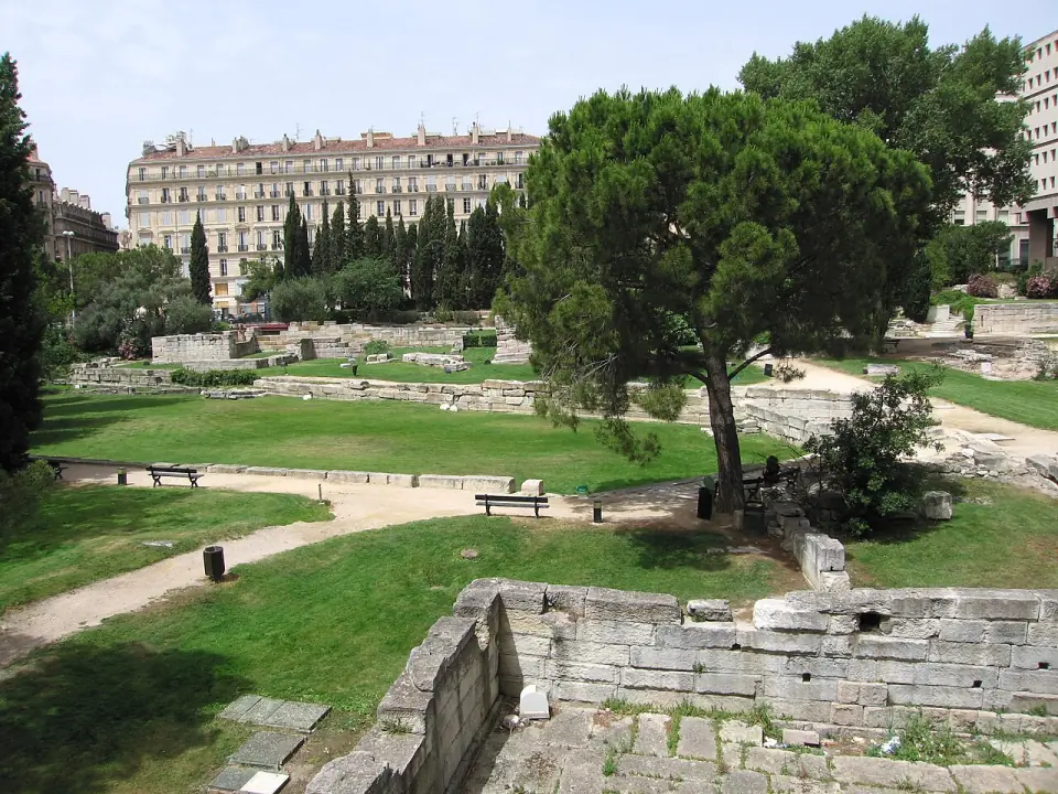 Le jardin des Vestiges à Marseille : pelouses, pins, murs antiques et immeubles du quartier