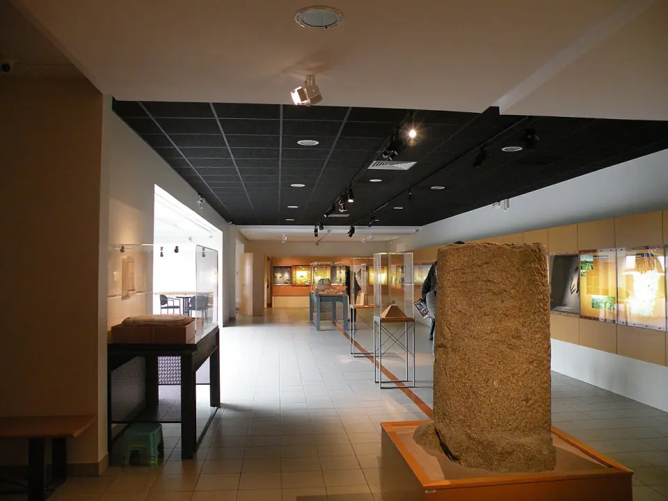 Salle d'exposition du musée archéologique de Jublains, avec bloc de pierre et vitrines