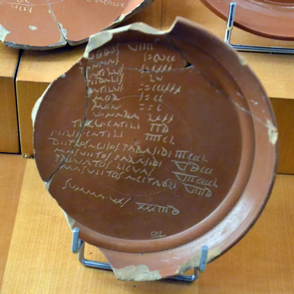 Plat de sigillée rouge portant une liste gravée en écriture cursive après cuisson