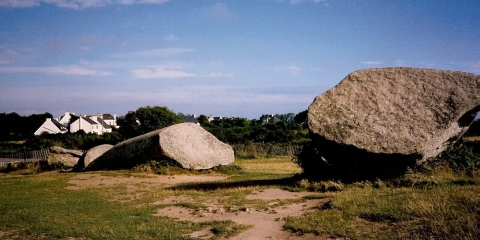 Fragments du Grand Menhir brisé de Locmariaquer, avec les maisons blanches du bourg en arrière-plan