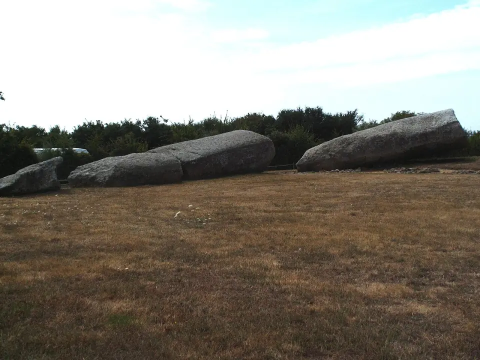 Les blocs du Grand Menhir brisé alignés dans un pré, vus de côté