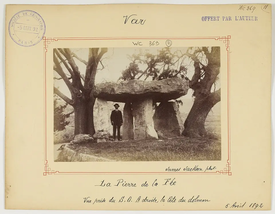 Photographie de 1892 de la Pierre de la Fée avec un visiteur, avant l'explosion de 1975