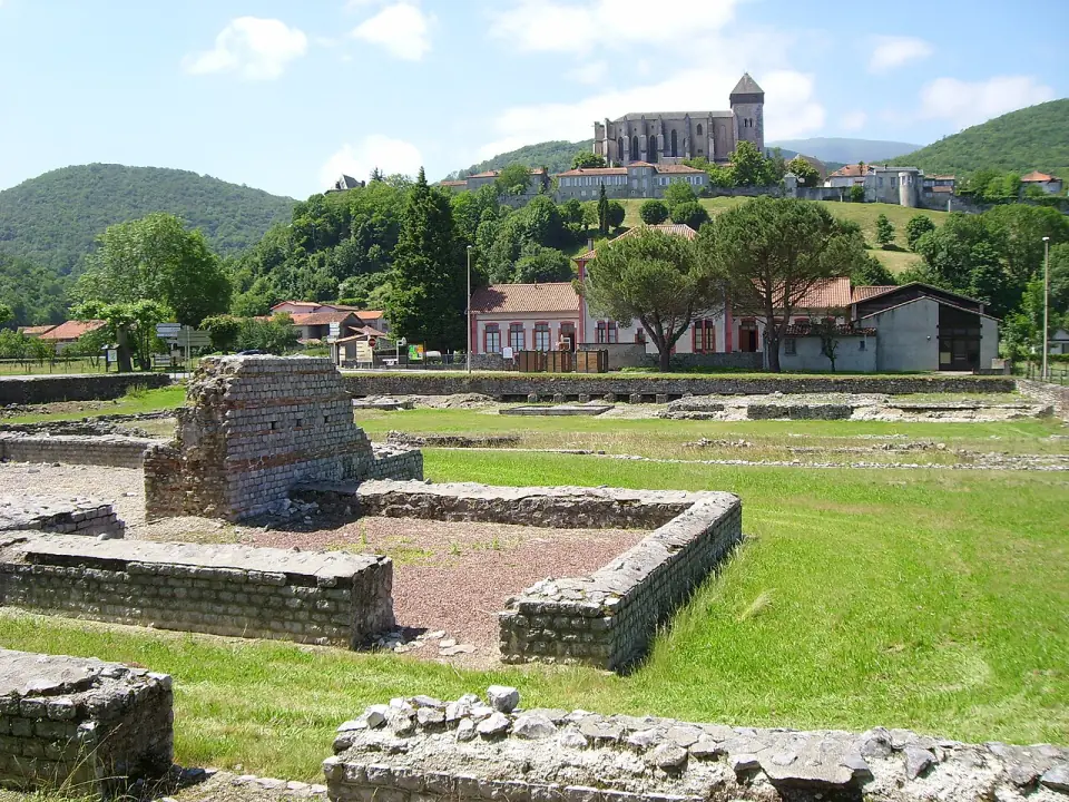Les murs bas des thermes du forum au premier plan, avec la cathédrale et la ville haute sur la colline