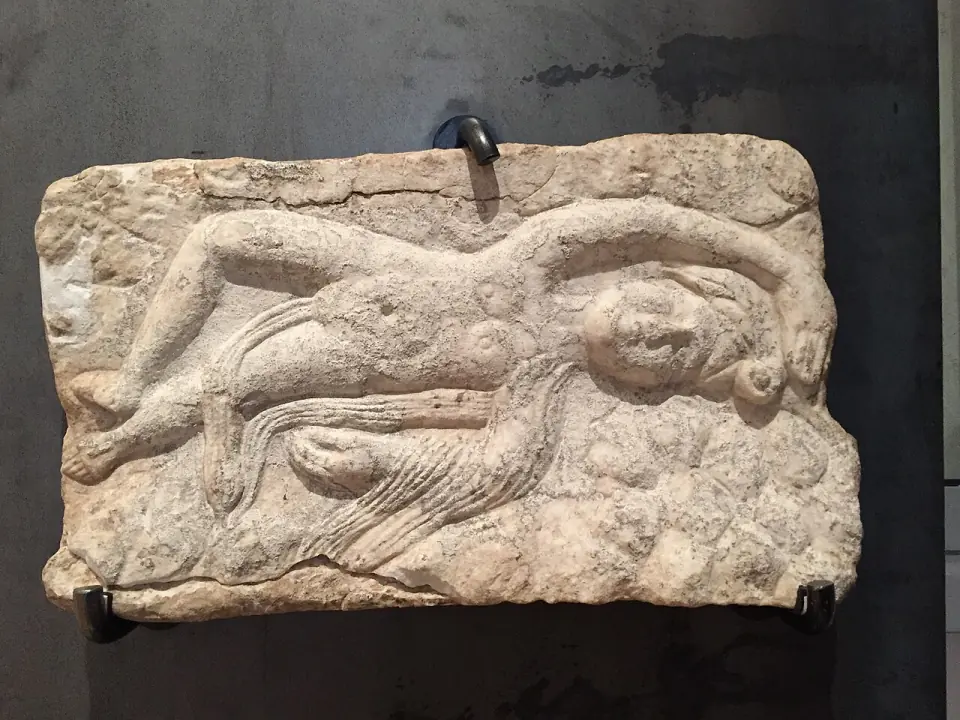 Bas-relief antique en marbre figurant Attis allongé, exposé au musée archéologique départemental