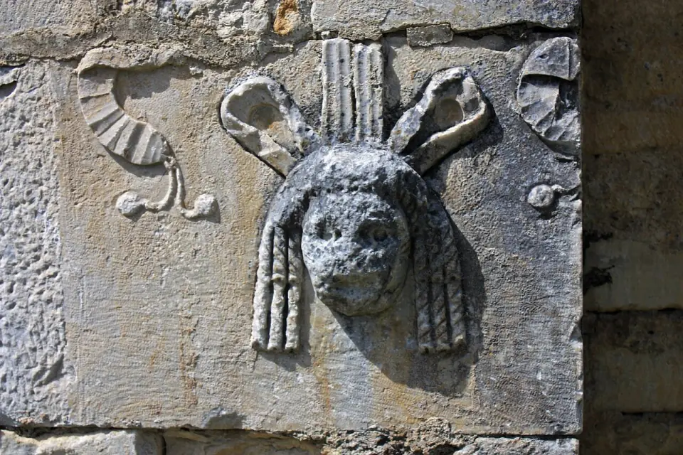 Masque de théâtre sculpté dans la pierre, réemployé sur la basilique Saint-Just de Valcabrère