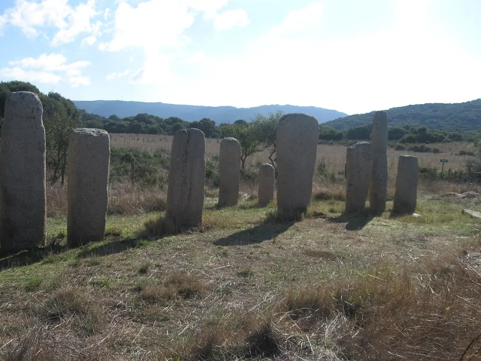 Alignement de menhirs d'I Stantari sur l'herbe sèche de Cauria, avec les collines au loin