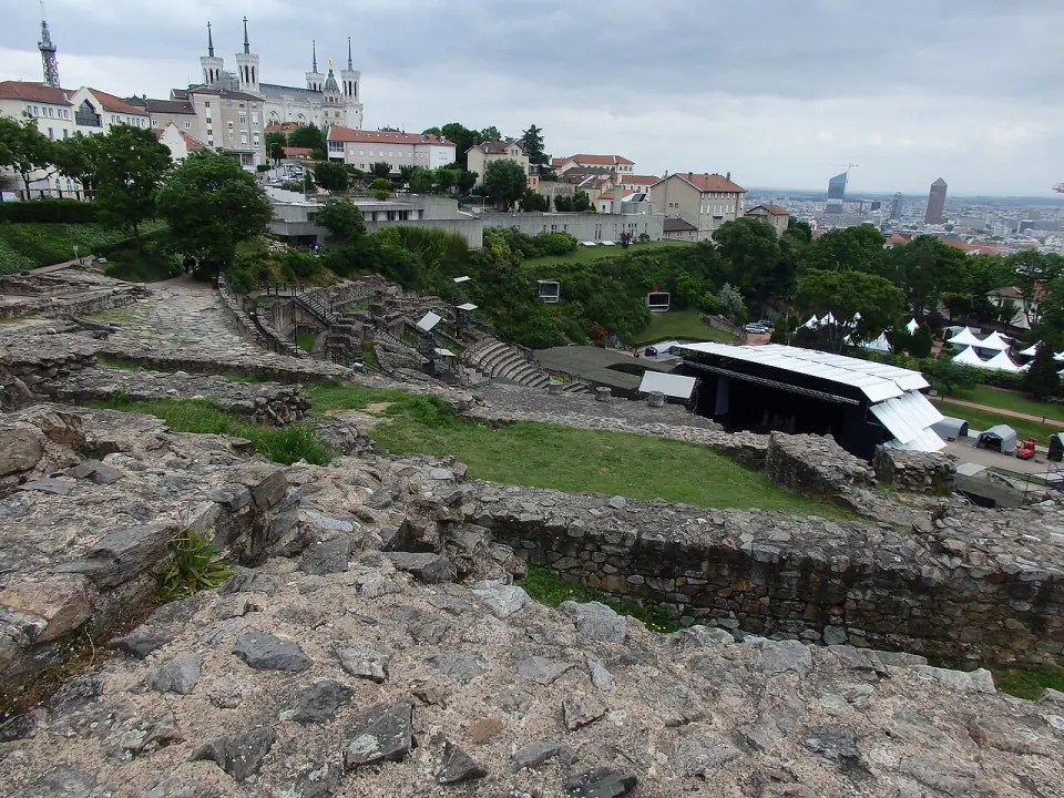 Vestiges du théâtre romain de Fourvière, avec la basilique et les toits de Lyon à l'arrière-plan