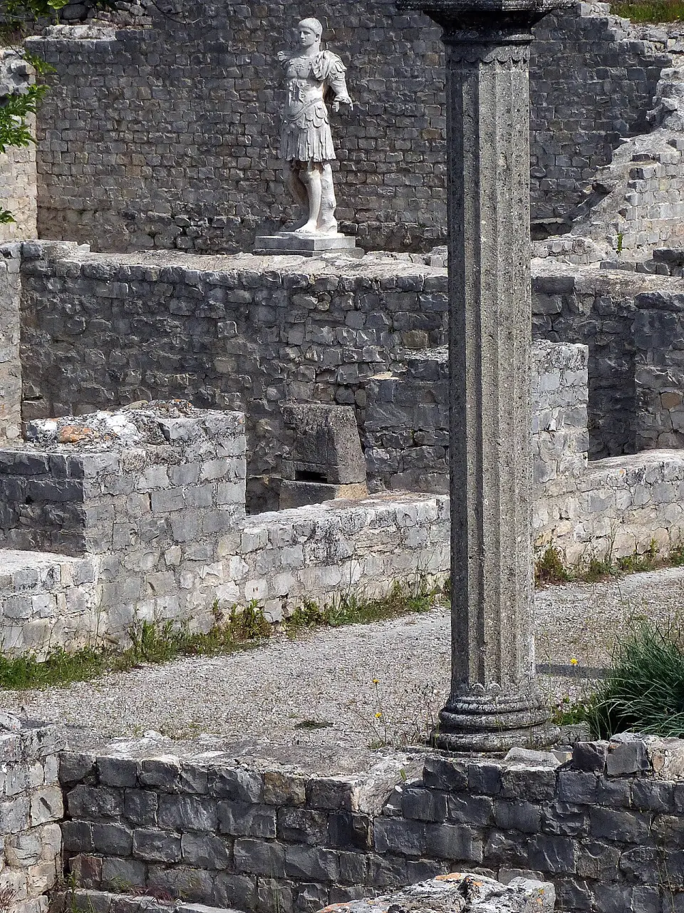 Colonne et statue au milieu des murs de pierre d'une maison romaine de Vaison-la-Romaine