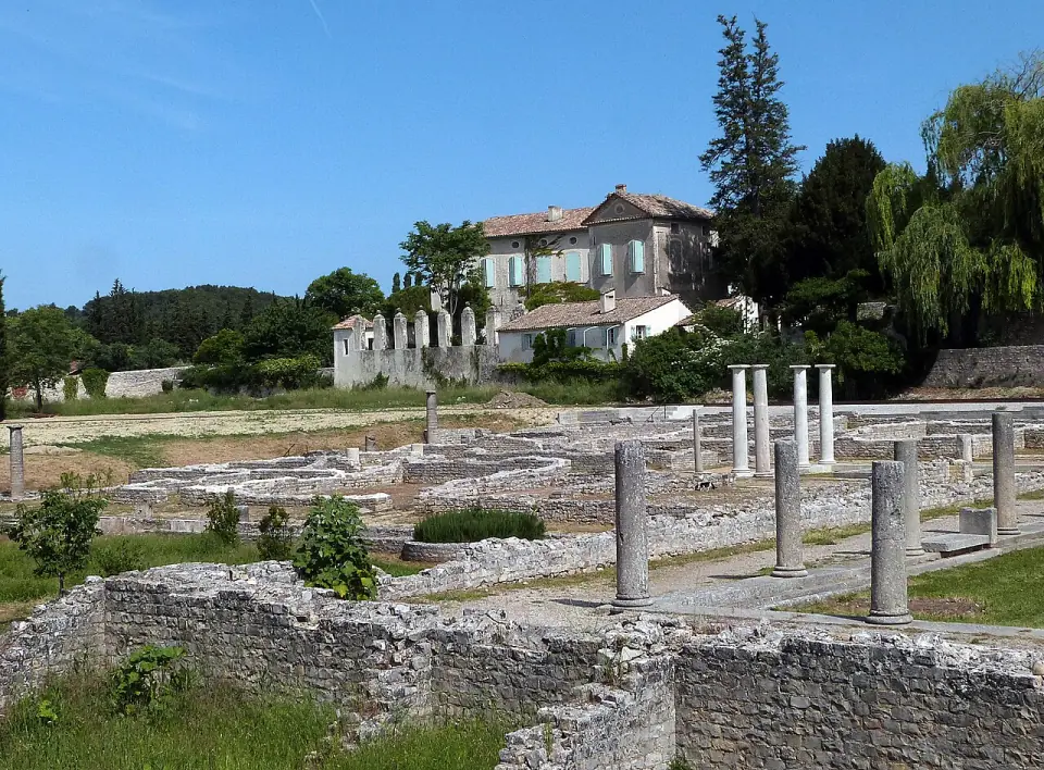 Colonnes et vestiges de maisons romaines à la Villasse, avec une bastide provençale en arrière-plan