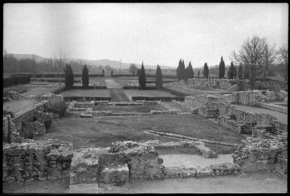 Vue d'ensemble des vestiges de la villa gallo-romaine de Montmaurin en 1974, en noir et blanc, avec cyprès et collines