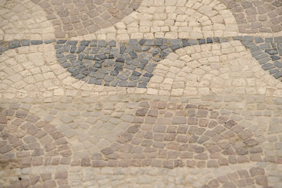 Détail d'une mosaïque de Séviac, avec petits cubes de pierre gris, beiges et rosés